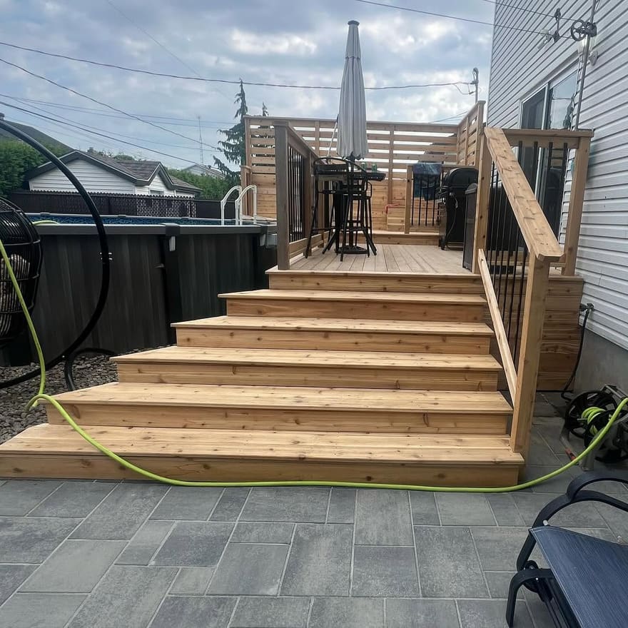 Large escalier en cèdre menant à une terrasse avec écran d’intimité